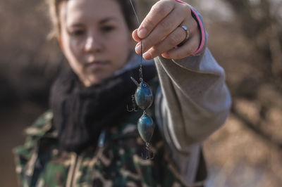 Close-up of woman holding blue fishing bait