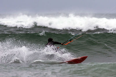 Man surfing in sea against sky