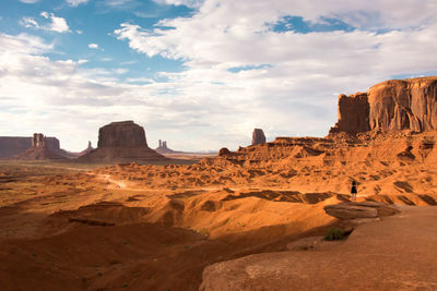 Woman standing on rock formation at monument valley