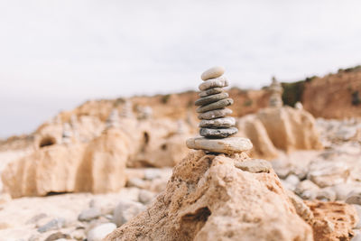 Close-up of stack of pebbles against sky