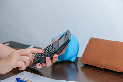 Close-up of person using mobile phone on table