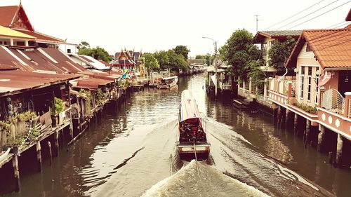 Boats in canal along buildings