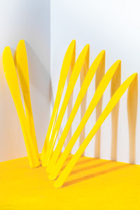 Close-up of yellow umbrella on table against white background