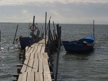 Boats moored in sea against sky
