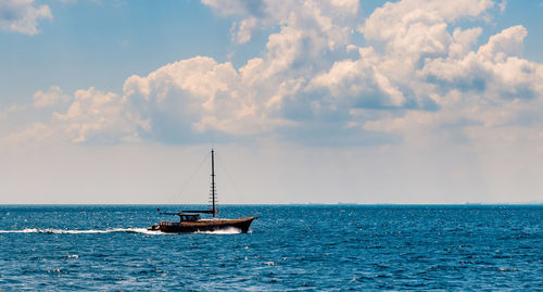 Sailboat sailing on sea against sky