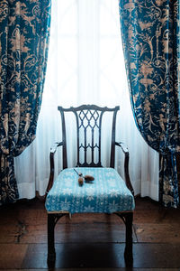 Thistle on the chair by the windows with open curtain