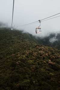 Overhead cable car against sky during foggy weather