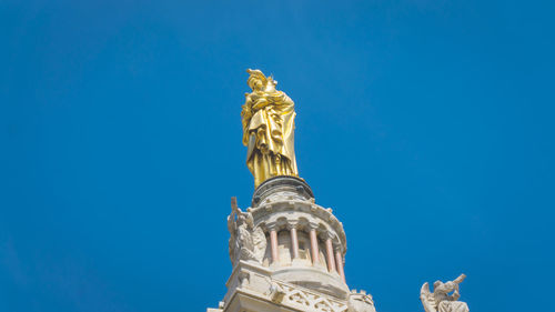 Low angle view of statue of temple against blue sky