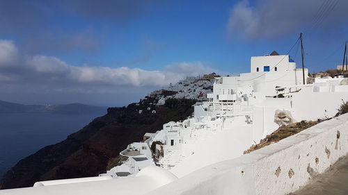 Buildings in city against cloudy sky