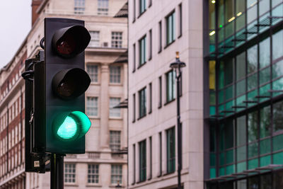 Low angle view of road signal against buildings