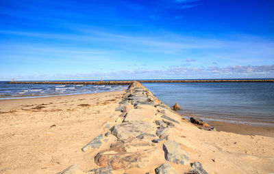 Scenic view of beach against blue sky