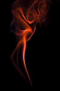 Close-up of orange smoke against black background