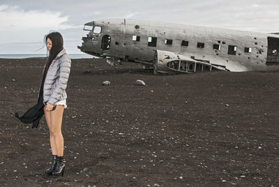 Beautiful woman posing at abandoned airplane wreck in iceland