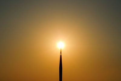 Close-up of illuminated lamp against sky during sunset