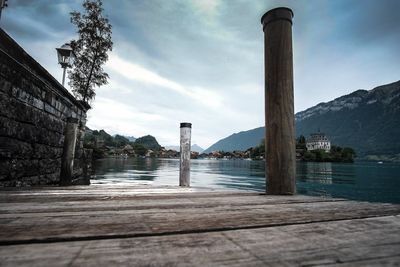 View of building by river against cloudy sky