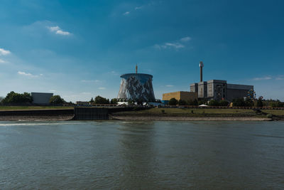 River by buildings against sky