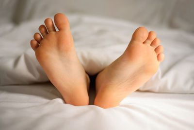 Low section of man lying on bed