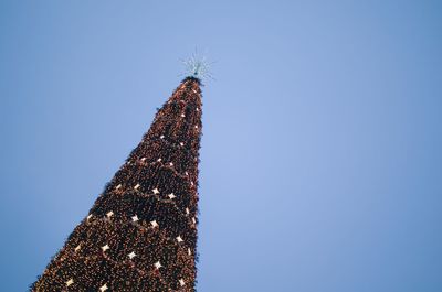 Low angle view of christmas tree against clear blue sky