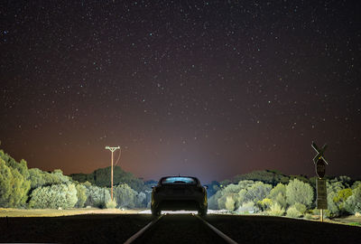 Car against sky at night on train tracks