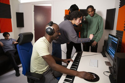 Portrait of sound engineers working with rappers in recording studio