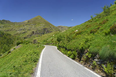 Road amidst green landscape against sky