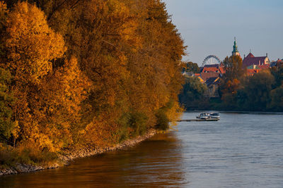 River amidst trees against sky during autumn