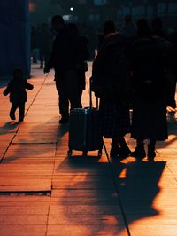 Rear view of people walking on street in city