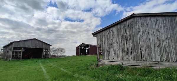 Panoramic shot of abandoned house on field against sky