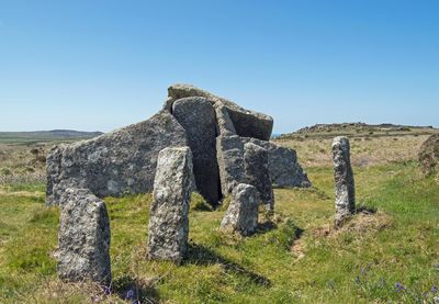 Old ruins on field against clear blue sky