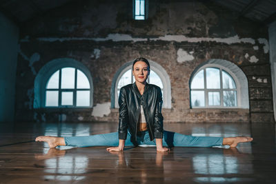 Full length of woman stretching at studio