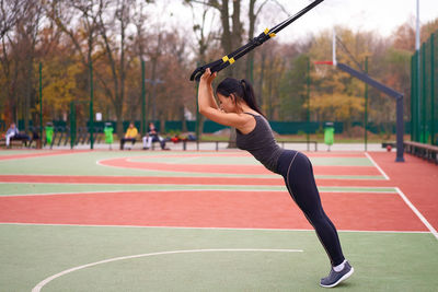 Full length of woman with arms raised in park