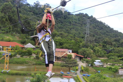 Full length of woman ziplining