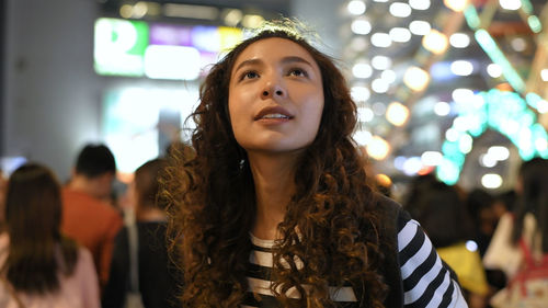 Portrait of young woman looking away outdoors