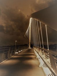 Surface level of empty footbridge against sky