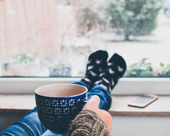 Low section of woman with coffee cup