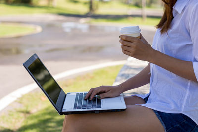 Midsection of woman using mobile phone