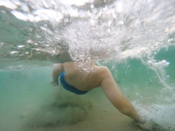 Rear view of man swimming in sea