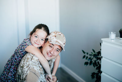 Portrait of girl embracing father in military uniform