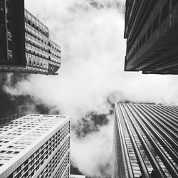 Low angle view of modern building against cloudy sky