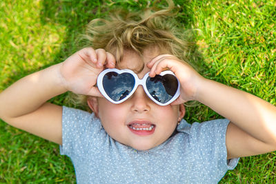 Portrait of young woman wearing sunglasses while sitting on grass