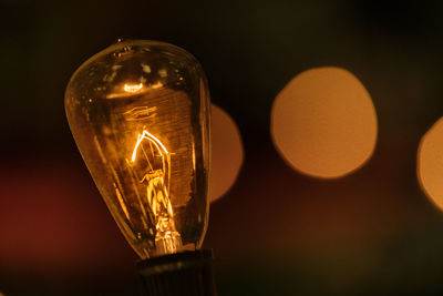 Close-up of illuminated light bulb at night