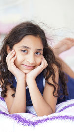 Portrait of smiling girl lying on bed