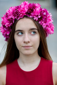Close-up portrait of beautiful young woman with pink flower