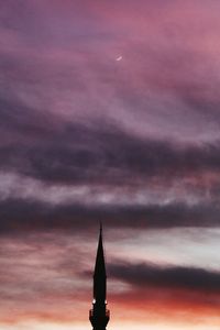 Low angle view of illuminated building against cloudy sky