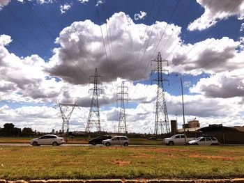 Electricity pylon on field against sky