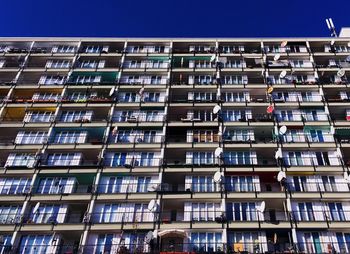 Low angle view of building windows against clear sky