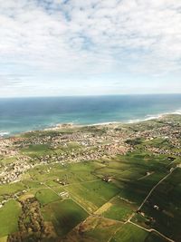 Aerial view of landscape by sea against sky