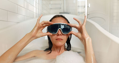 Masked woman dives into the bathtube