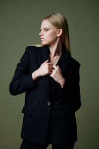 Young woman standing against gray background