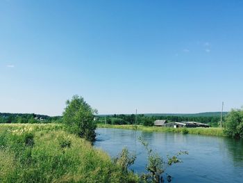 Scenic view of lake against clear blue sky